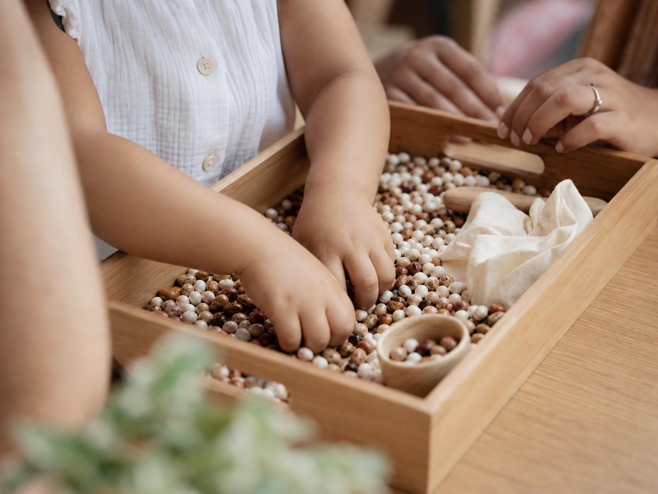 Toddler exploring sensory and messy play materials on a Monday Discover session